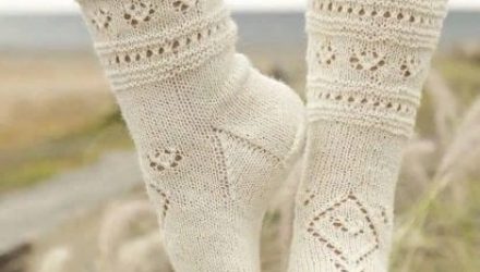 Нежные вязаные носки украшены орнаментами из ажурных элементов.